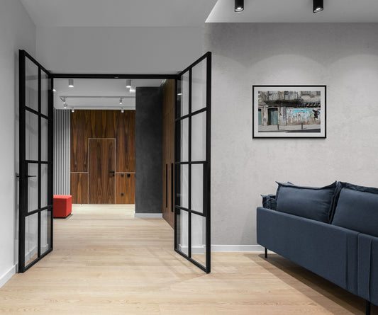 Modern living room with open black-framed doors and a blue sofa. Abandoned Store, Porto, Portugal, Original Photograph by Kim A. Bailey