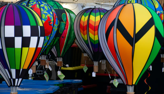 A photograph of multiple hot air balloon decorations with vibrant, abstract patterns in a variety of colors.