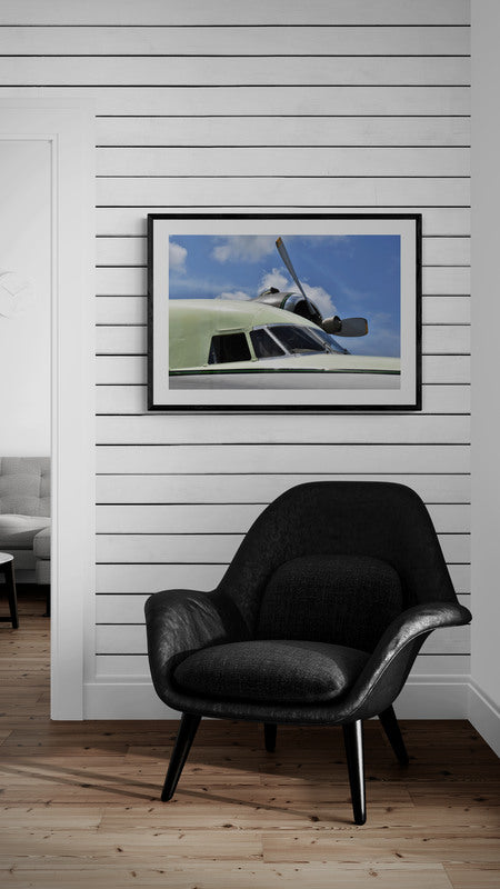 Black armchair in a room with a framed picture of a helicopter on the wall.