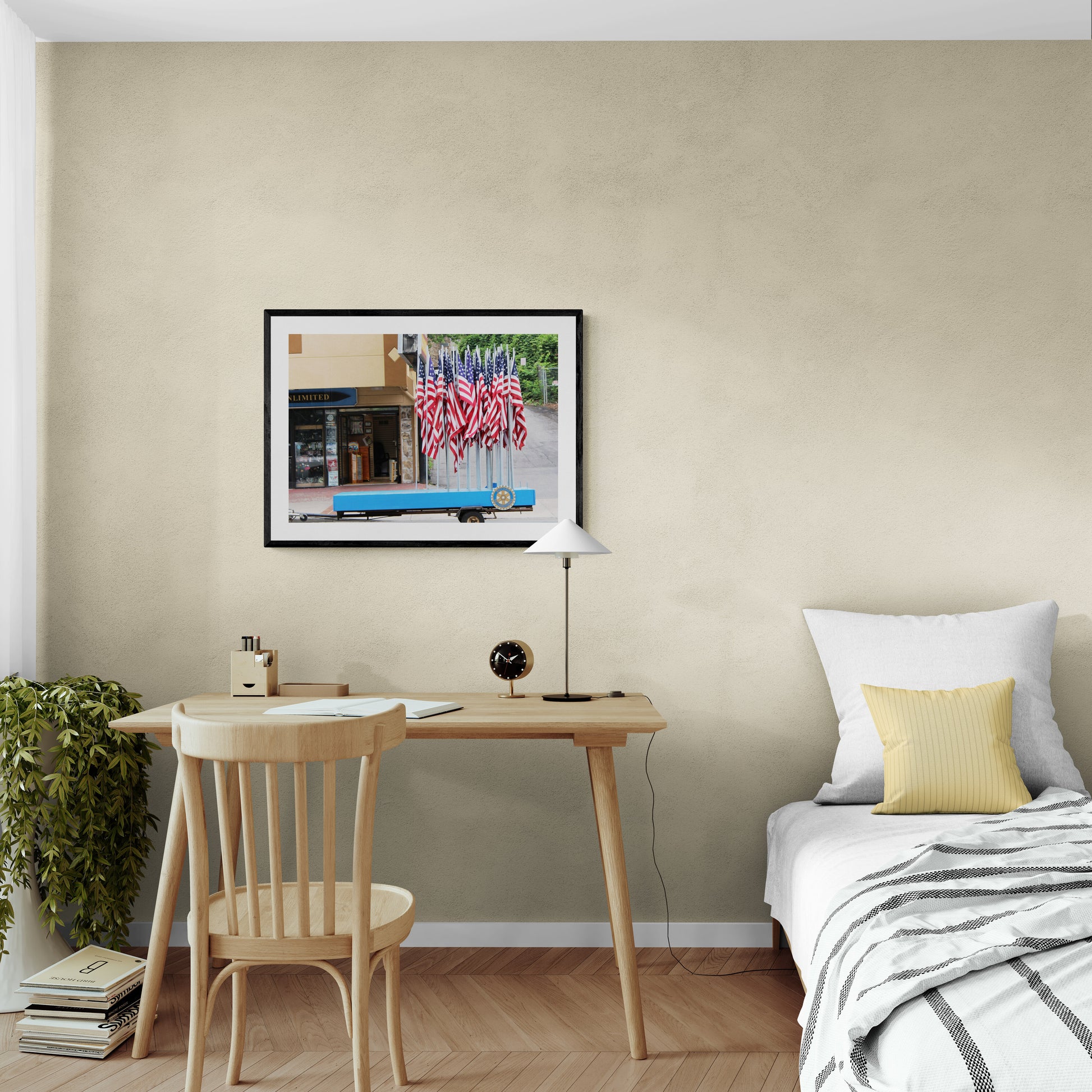 Small home office with framed picture, desk, and chair against a beige wall.