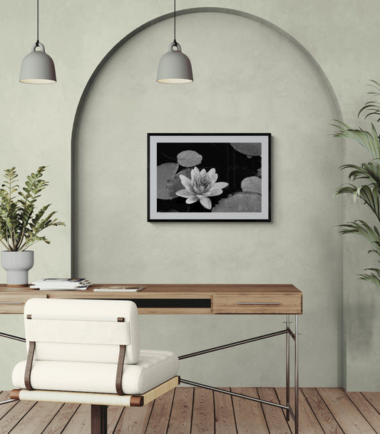 Modern office with a framed black and white waterlily print on a wall, a desk, and a chair.