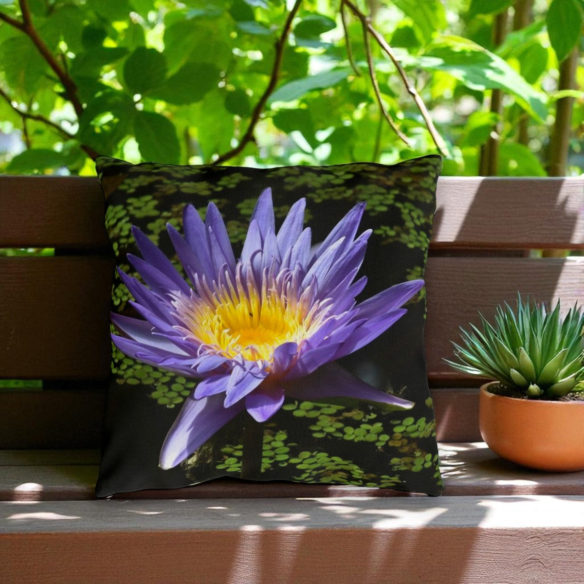 Pillow with a purple flower design on a wooden bench outdoors