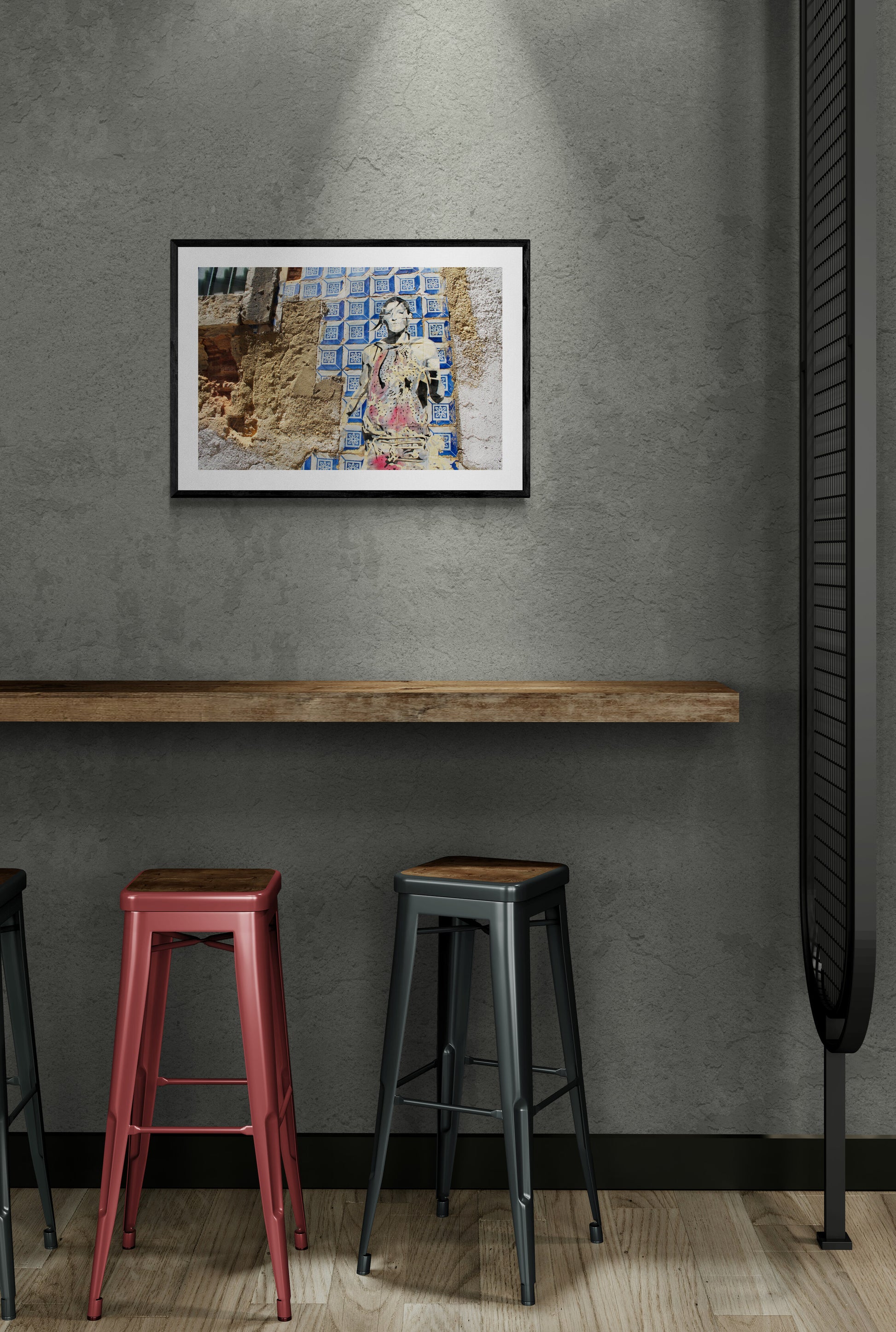 Framed artwork on a gray wall with bar stools below.