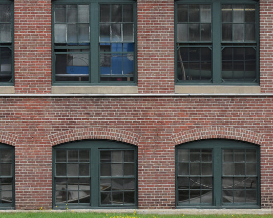 A color photograph featuring a row of arched windows on a brick wall, with green trim and a visible reflection of a boat in one of the windows. Boat Museum Windows, Original Photograph by Kim A. Bailey