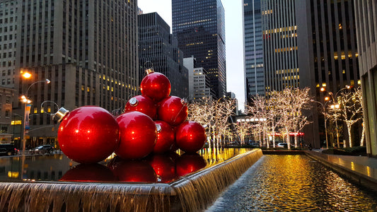 Photograph of red oversized ball ornaments in a fountain in Midtown Manhattan, New York City, during the holiday season.
