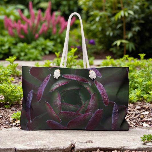 Tote bag with succulent design on a wooden surface with plants in the background
