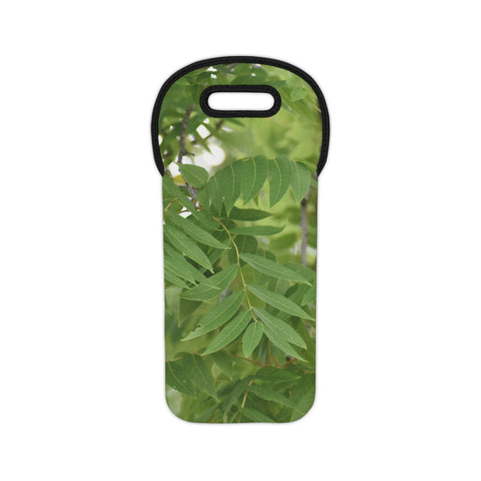 A neoprene wine tote bag featuring a photograph of tree leaves in green and white tones, with black trim and a carrying handle.