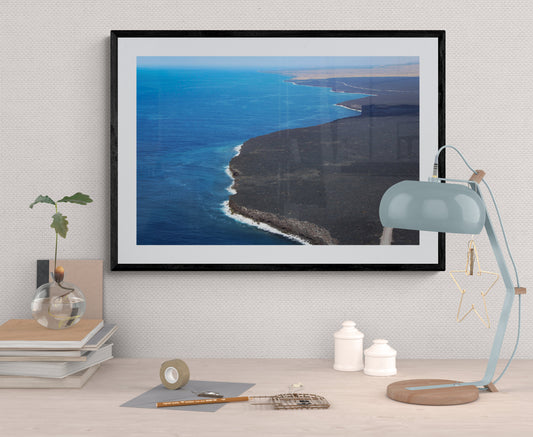 Framed photograph of a coastal landscape on a wall with decorative items.