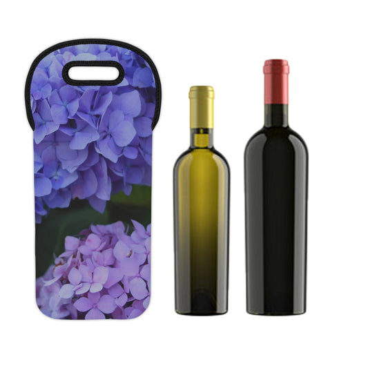 Wine carrier with purple floral design next to two wine bottles on a white background