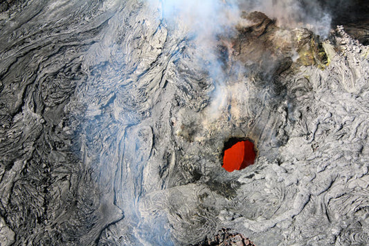 An aerial photograph of a lava tube at Kilauea volcano, Hawaii, with wisps of smoke billowing from its depths. Lava Tube of Kilauea, Hawaii, Original Photograph by Kim A. Bailey