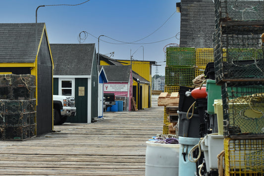 A row of colorful lobster shacks and traps on a dock with a clear blue sky in the background. Maine Lobster Original Photograph by Kim A. Bailey