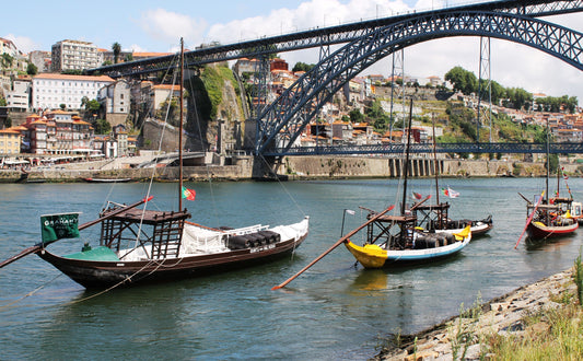 Photograph of the Maria Pia Bridge in Porto, Portugal, featuring small fishing boats anchored near the bridge. Maria Pia Bridge, Porto Original Photograph by Kim A. Bailey