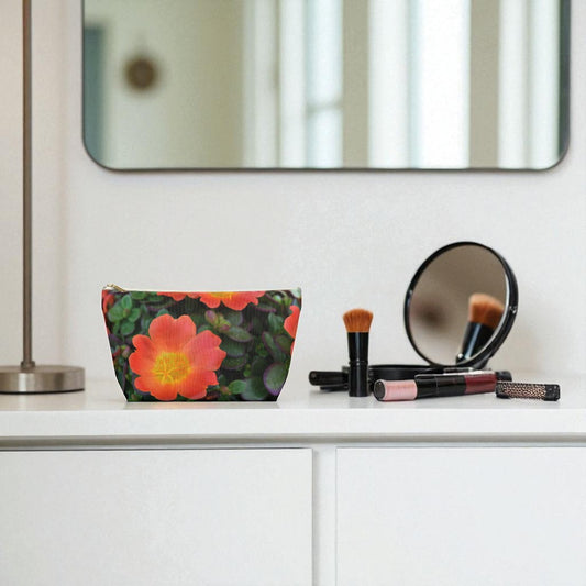 Makeup brushes and a floral pouch on a white surface with a mirror in the background.