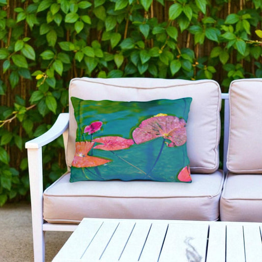 Decorative pillow with floral design on a beige outdoor sofa against a green foliage background