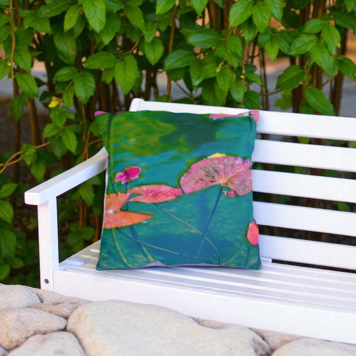 Decorative pillow with floral design on a white bench outdoors.