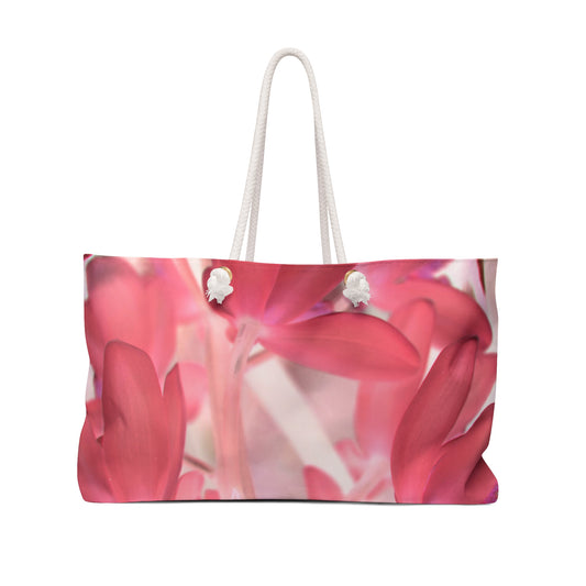A large tote bag featuring a pink tinted orchid photograph, with rope handles and a white sheeting interior lining.