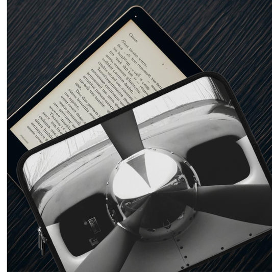 Tablet displaying a black and white image of a car interior on a dark textured surface.