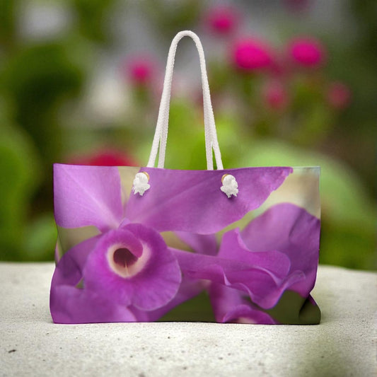 Tote bag with purple orchid design on a blurred natural background