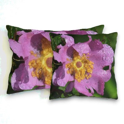 Two decorative pillows with pink flowers and green leaves on a white background