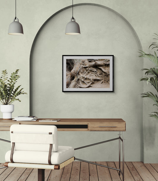 Modern office setup with a wooden desk, white chair, and framed artwork on a light green wall.