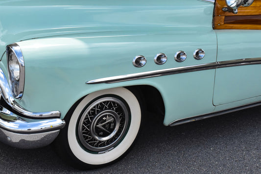 Close-up of a vintage car's front wheel and fender