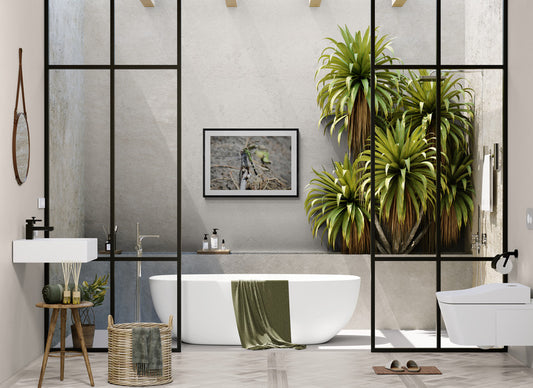 Modern bathroom with a freestanding bathtub, plants, and a glass partition.
