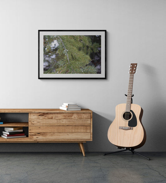 Acoustic guitar on a stand next to a wooden sideboard with a framed picture on the wall. Snow on a Pine Tree, Original Photograph by Kim A. Bailey