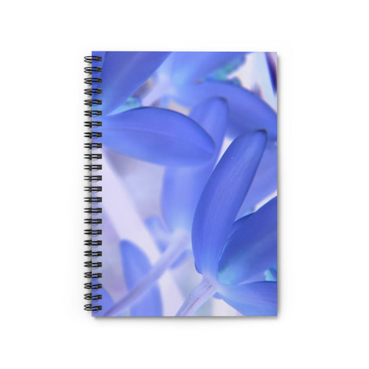 A spiral notebook with a front cover print of blue tinted orchids and a dark grey back cover.