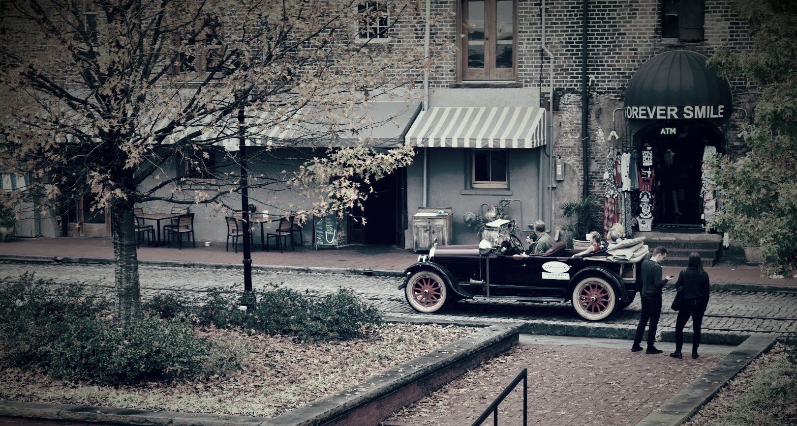 Vintage car parked in front of a building with 'Reverie Smile' sign.