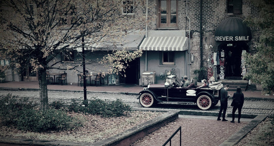 Vintage car parked in front of a building with 'Reverie Smile' sign.