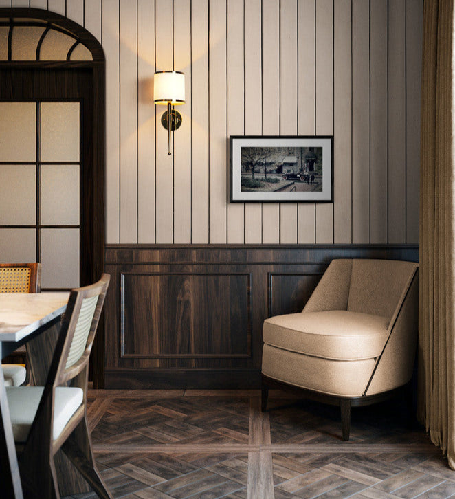 Beige armchair in a room with wooden paneling and a framed picture on the wall.