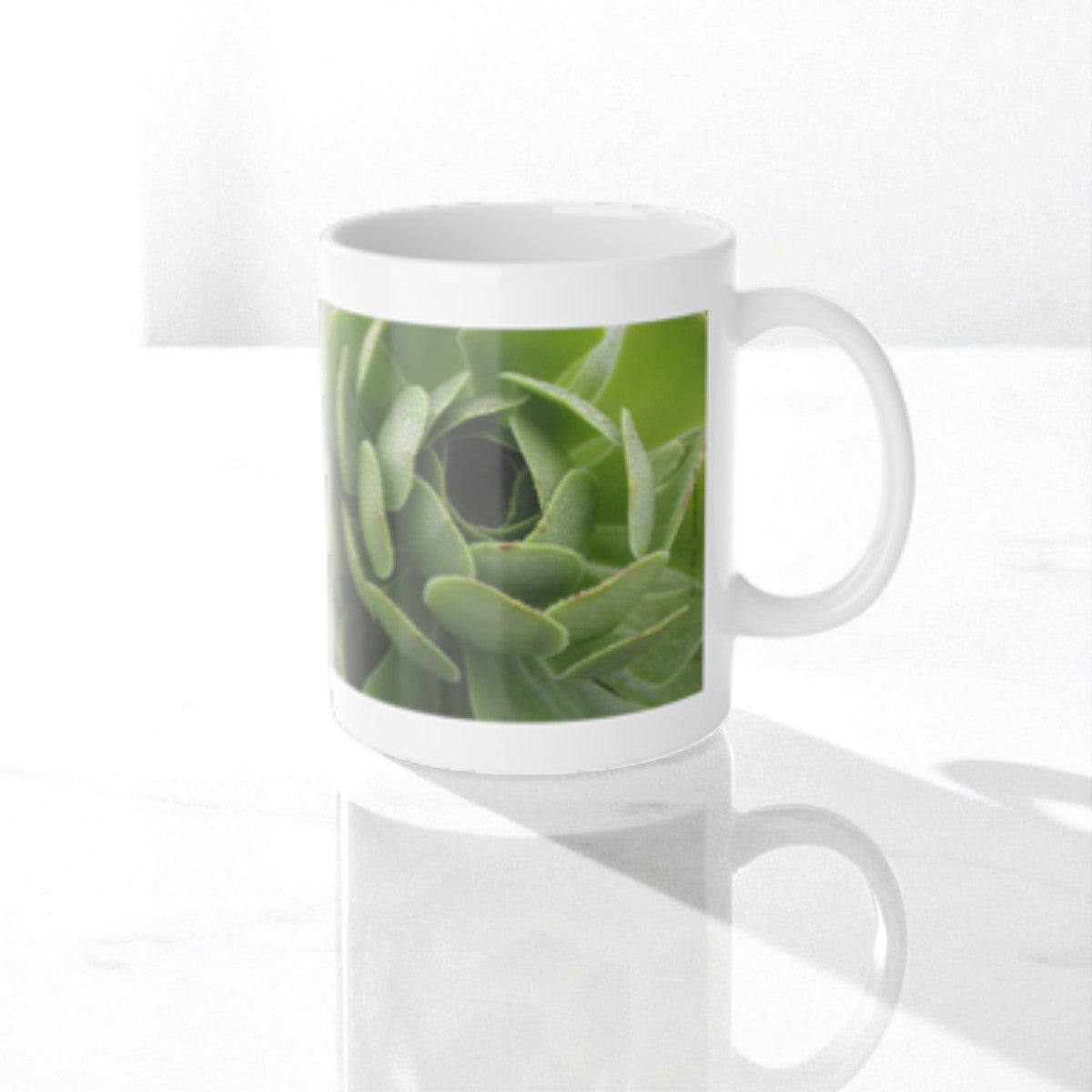 White mug with a green succulent plant design on a white background