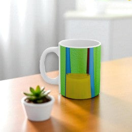 Colorful mug on a wooden table with a plant and vase in the background