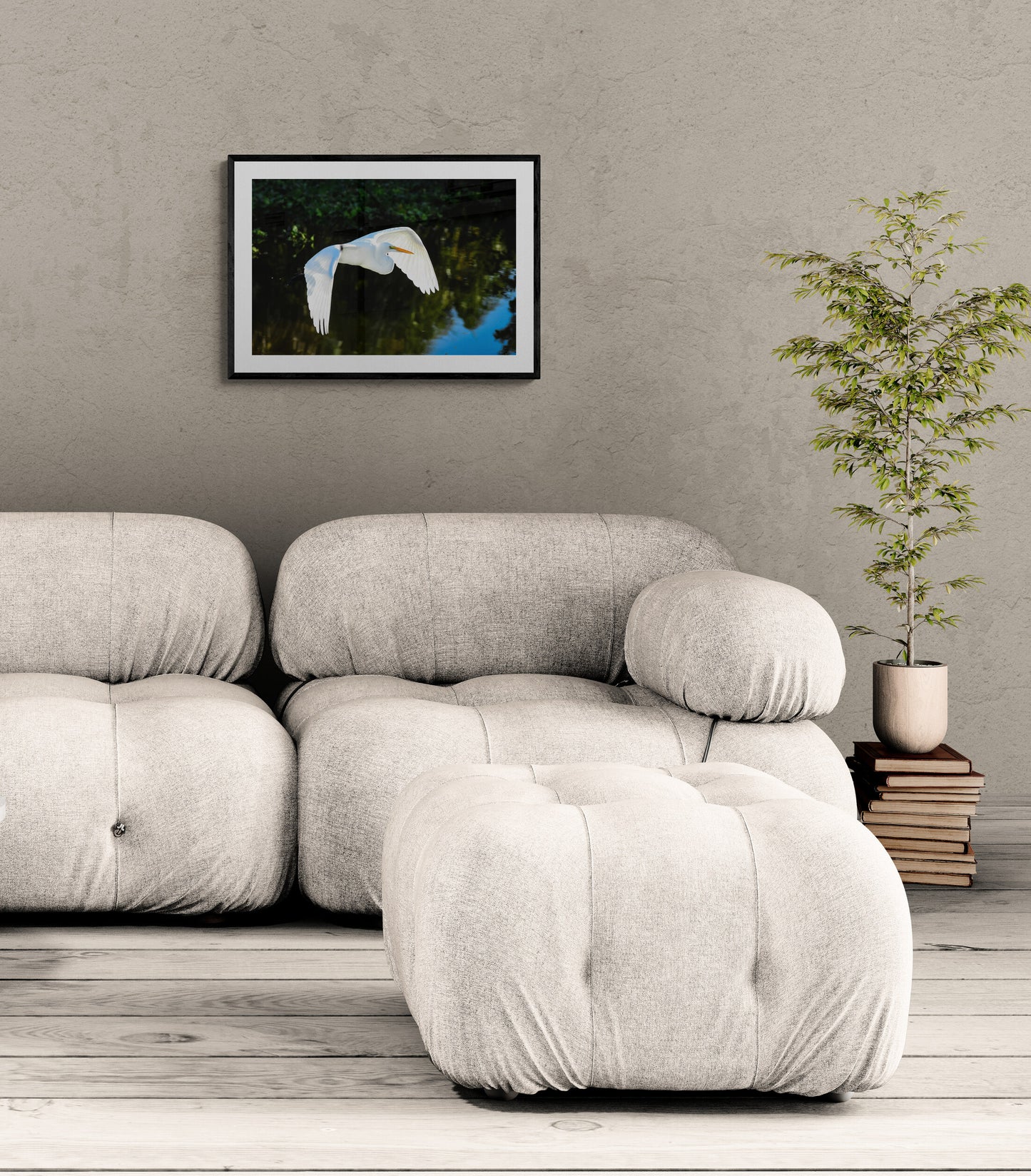 Modern living room with a beige sofa, framed picture on the wall, and a plant.