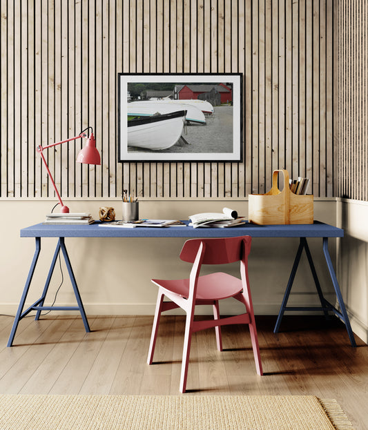 Modern home office with blue desk, pink chair, and artwork on wooden wall. Wooden Boats Original Photograph by Kim A. Bailey