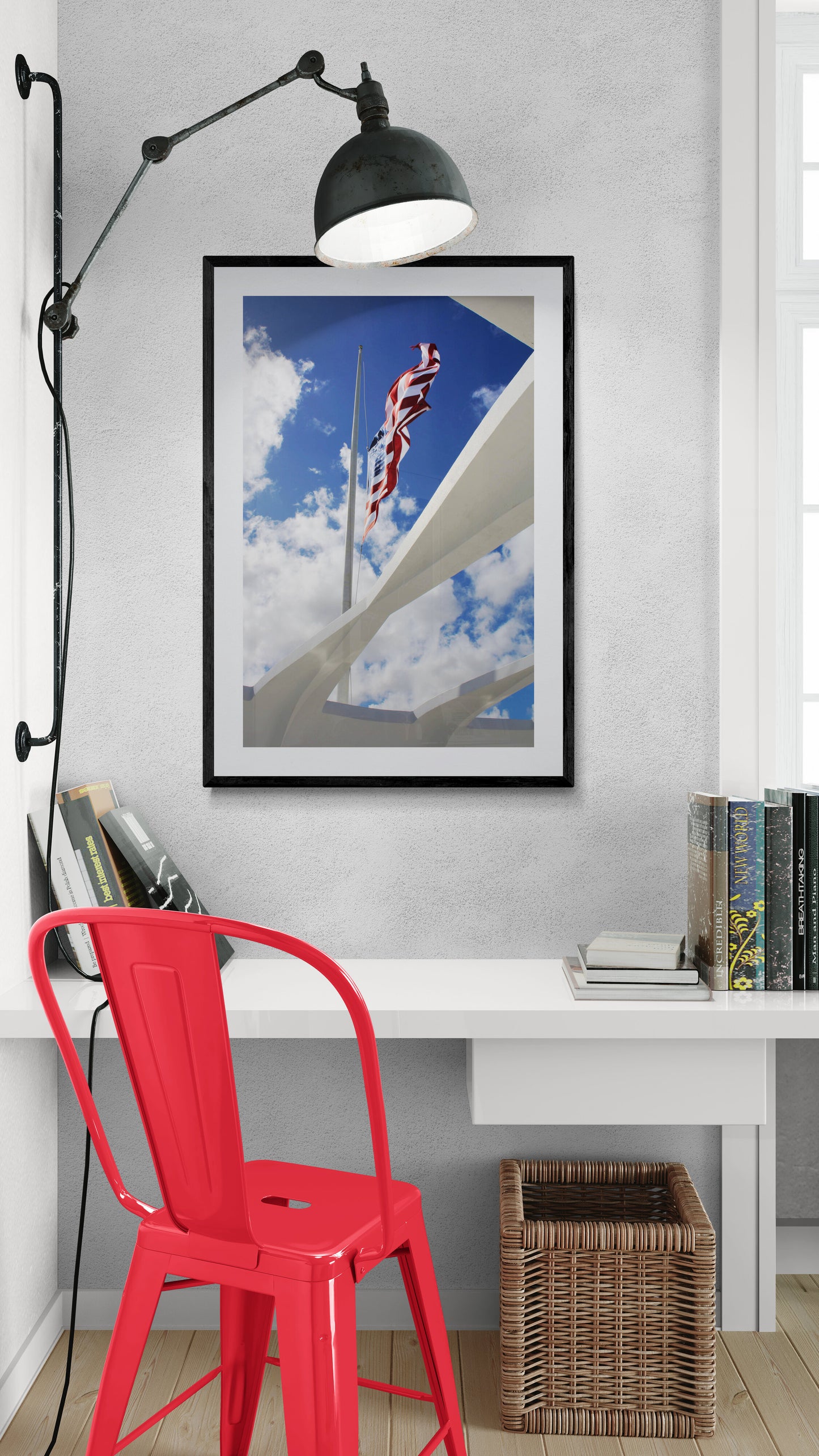 Framed picture of a flag against a blue sky in a room with a red chair and bookshelf.