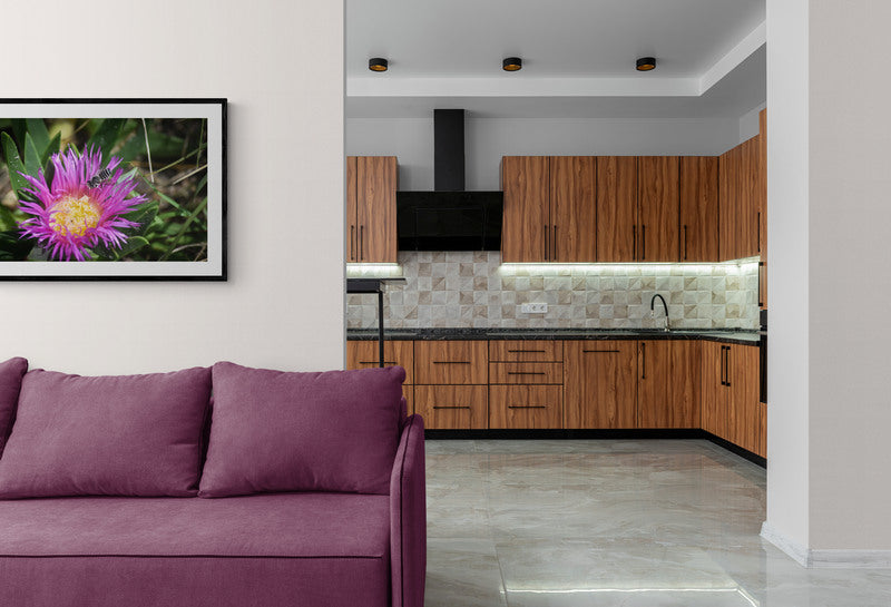 Living room with purple sofa and kitchen in the background