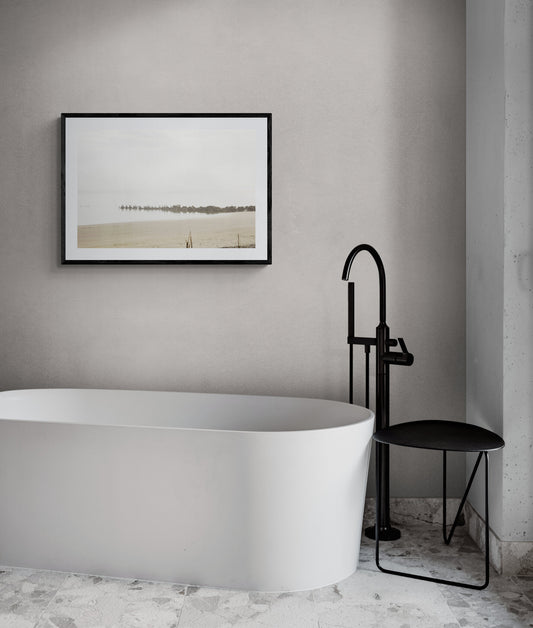 Minimalist bathroom with white bathtub and black fixtures.