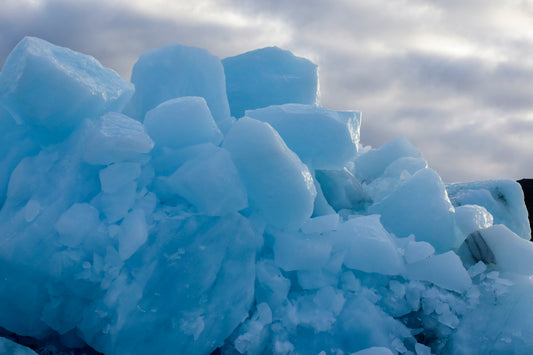 A photograph of blue icebergs in Iceland, with a focus on the vibrant blue color and the rugged texture of the ice.