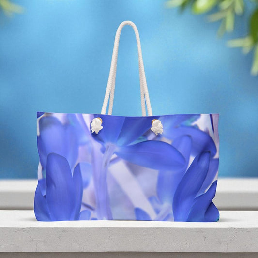 Blue floral-patterned bag with white handles on a blue background