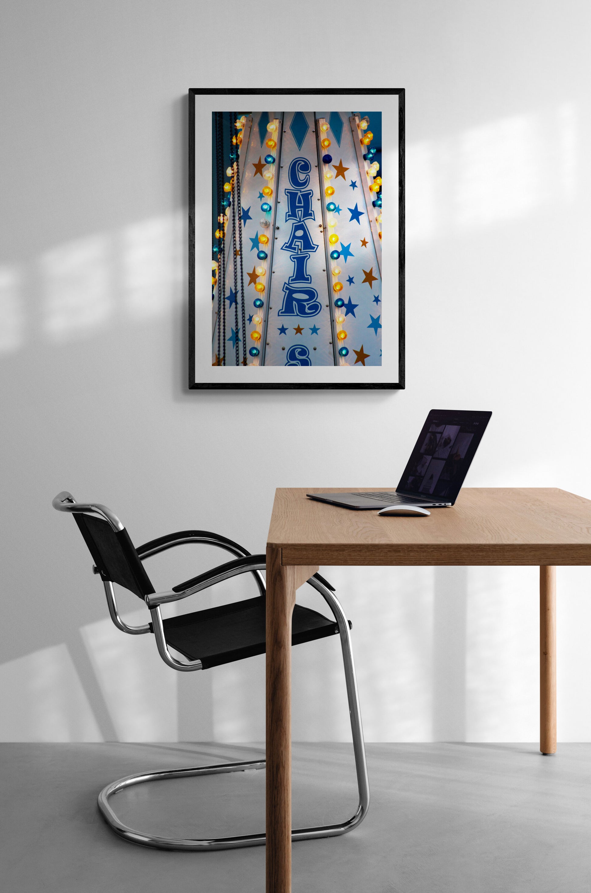 Modern office with a desk, chair, and framed artwork on the wall.