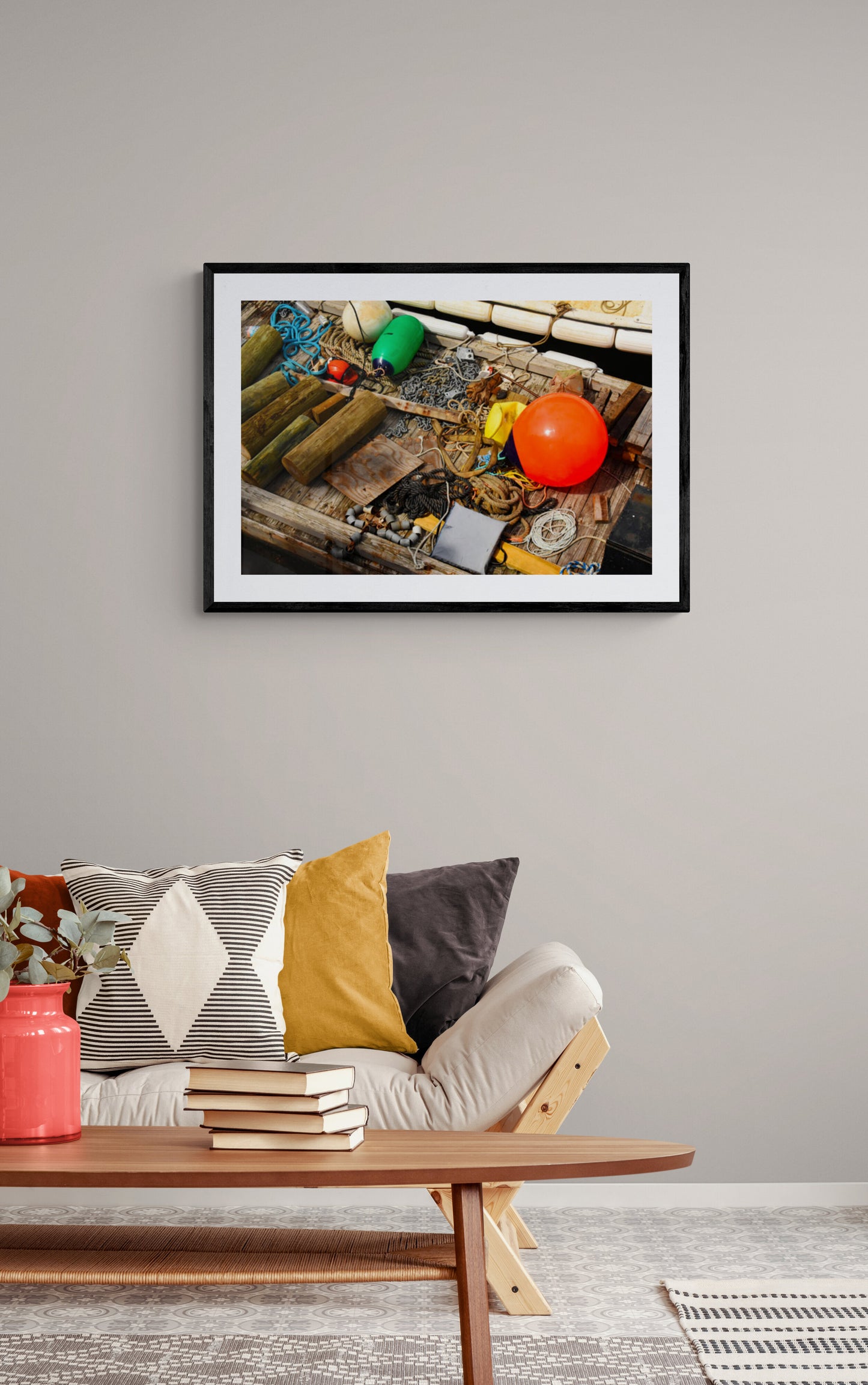 Framed photograph of a fishing net with colorful items above a sofa in a living room.