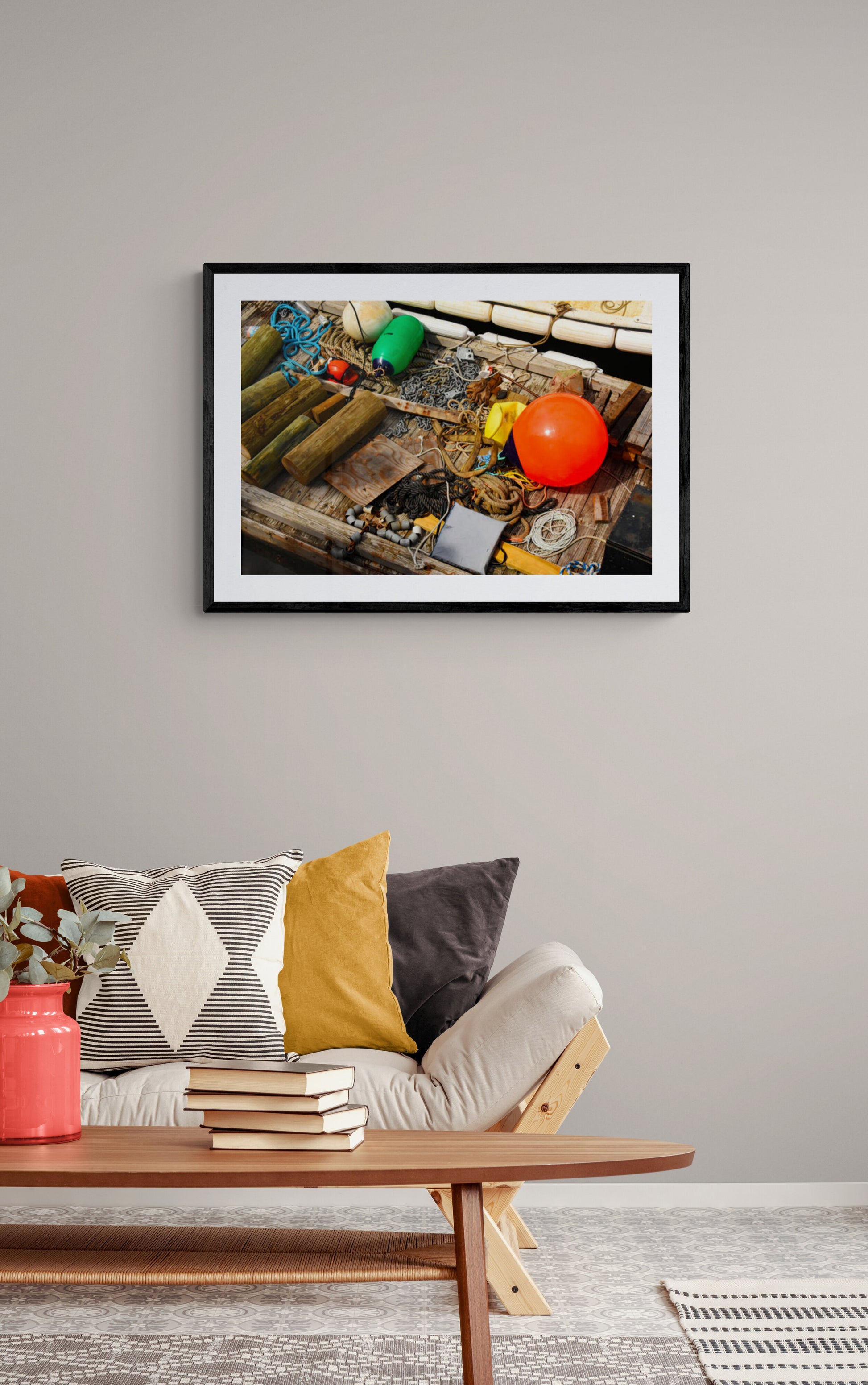 Framed photograph of a fishing net with colorful items above a sofa in a living room.