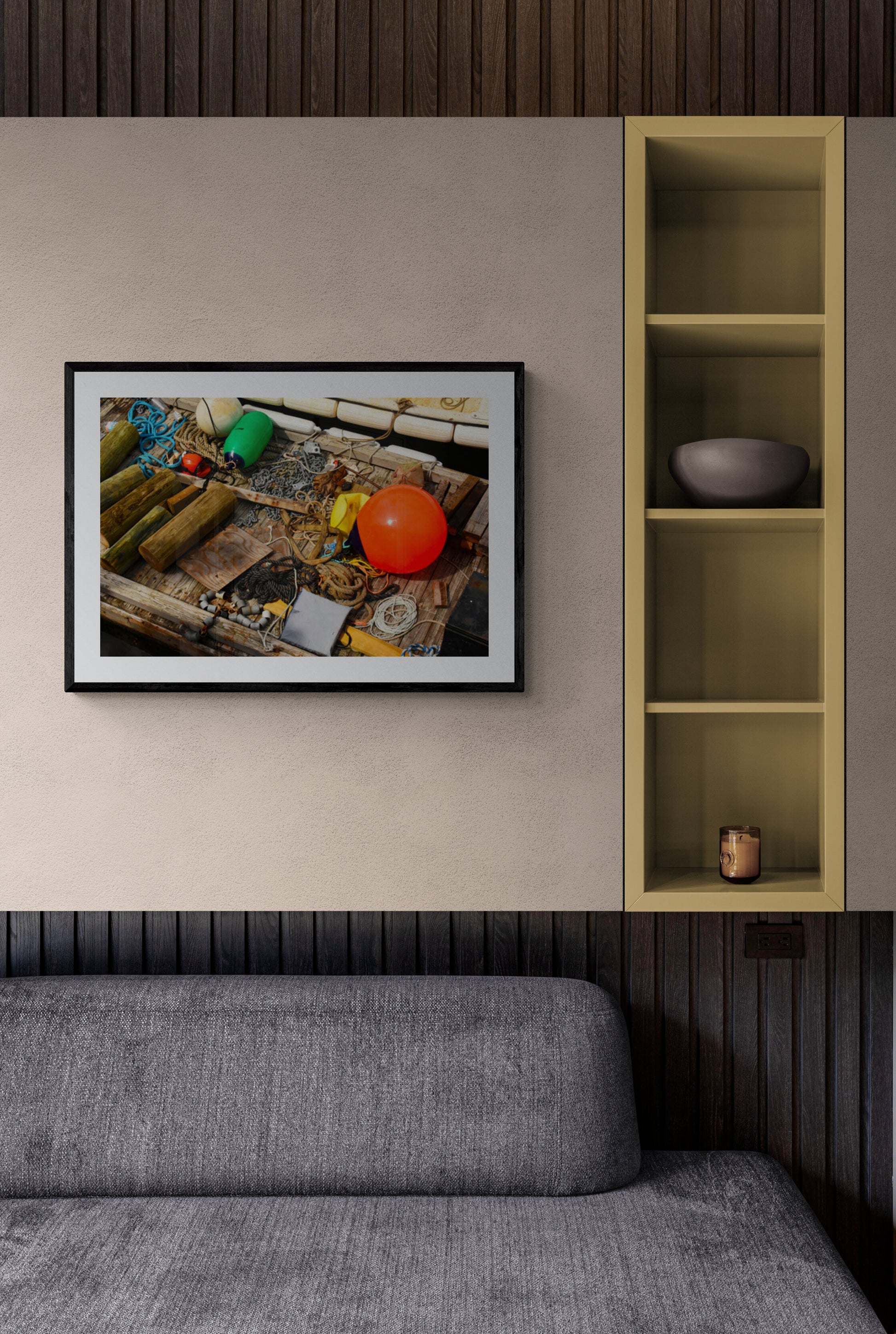 Framed photograph of a still life arrangement on a table, above a gray sofa.