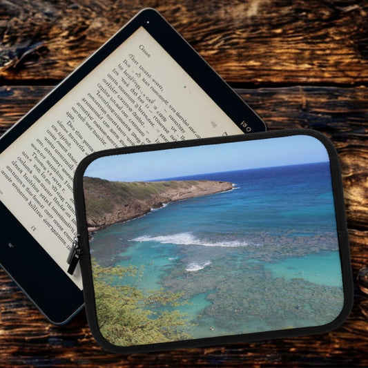 Tablet displaying a scenic view of a coastal landscape on a wooden surface.