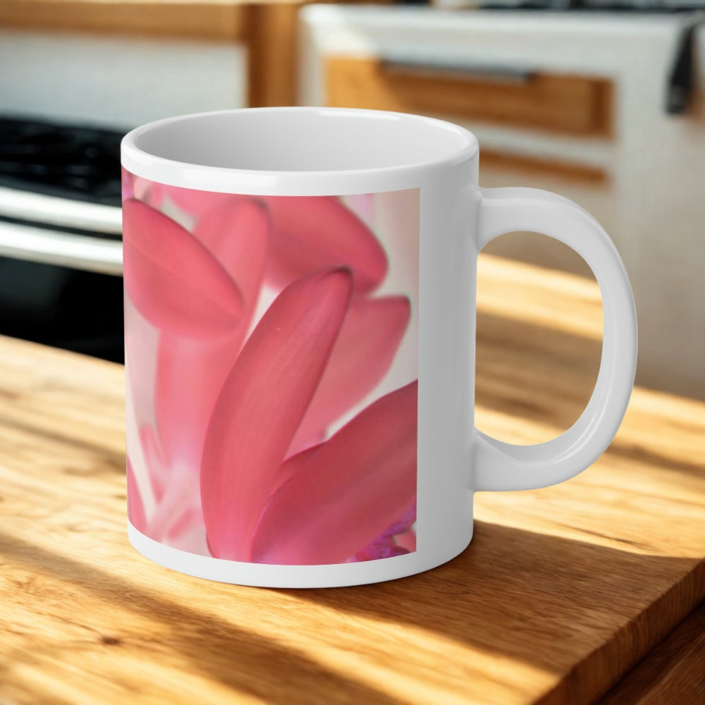 White mug with pink floral design on a wooden surface