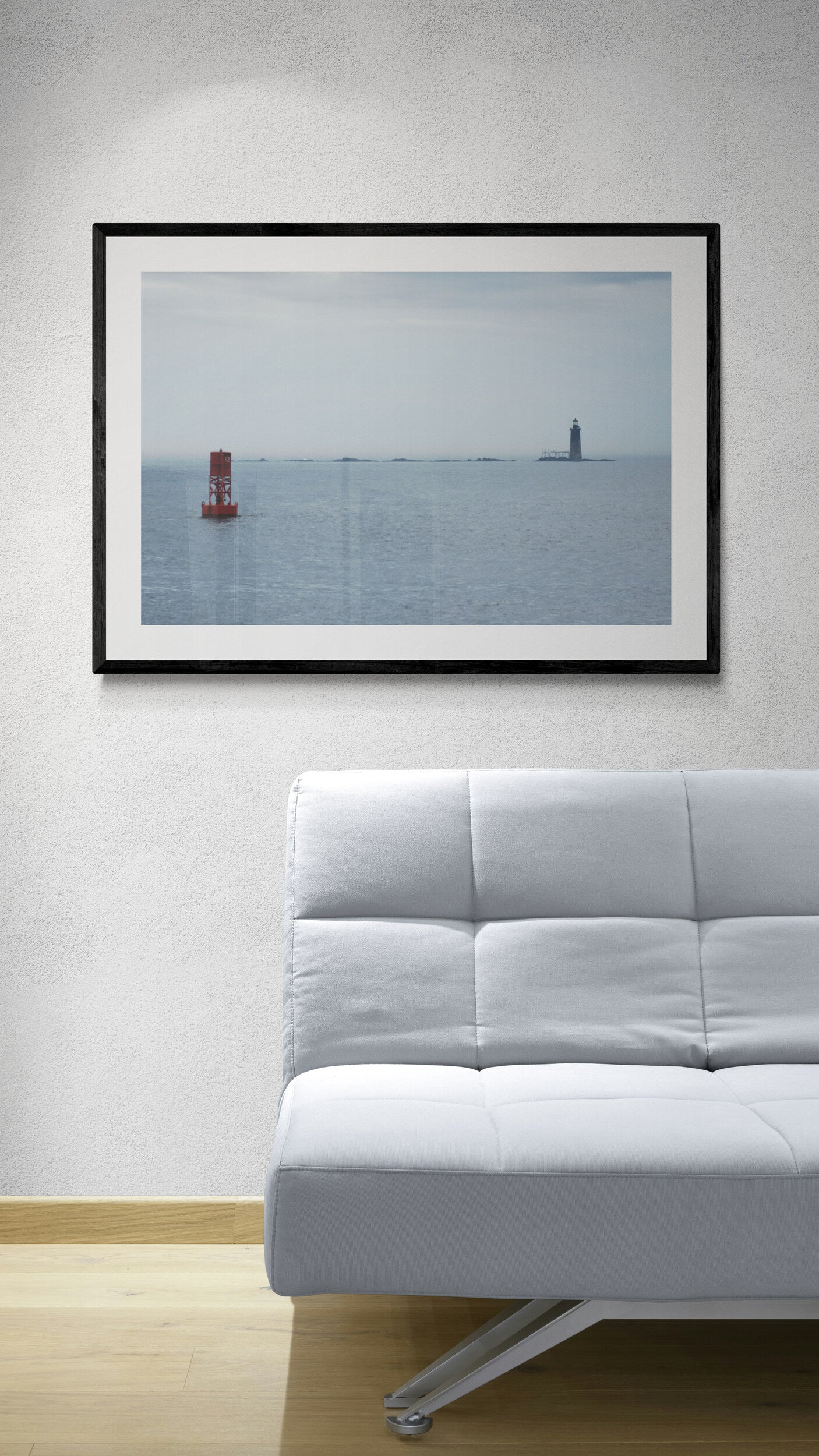 Framed photograph of a lighthouse on an ocean horizon above a white sofa. Lighthouse and Buoy Original Photograph by Kim A. Bailey