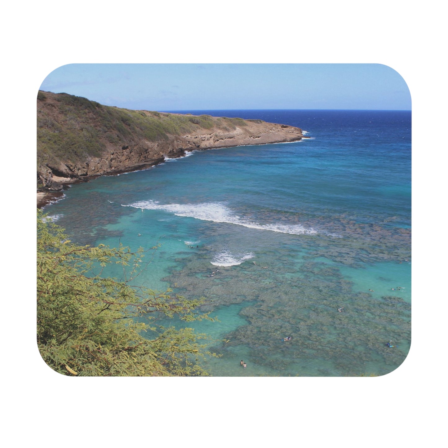 A mouse pad featuring a beach scene with clear blue water and a coastal landscape.