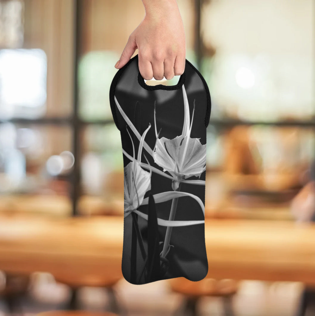 Black bag with white floral design held by a hand in an indoor setting
