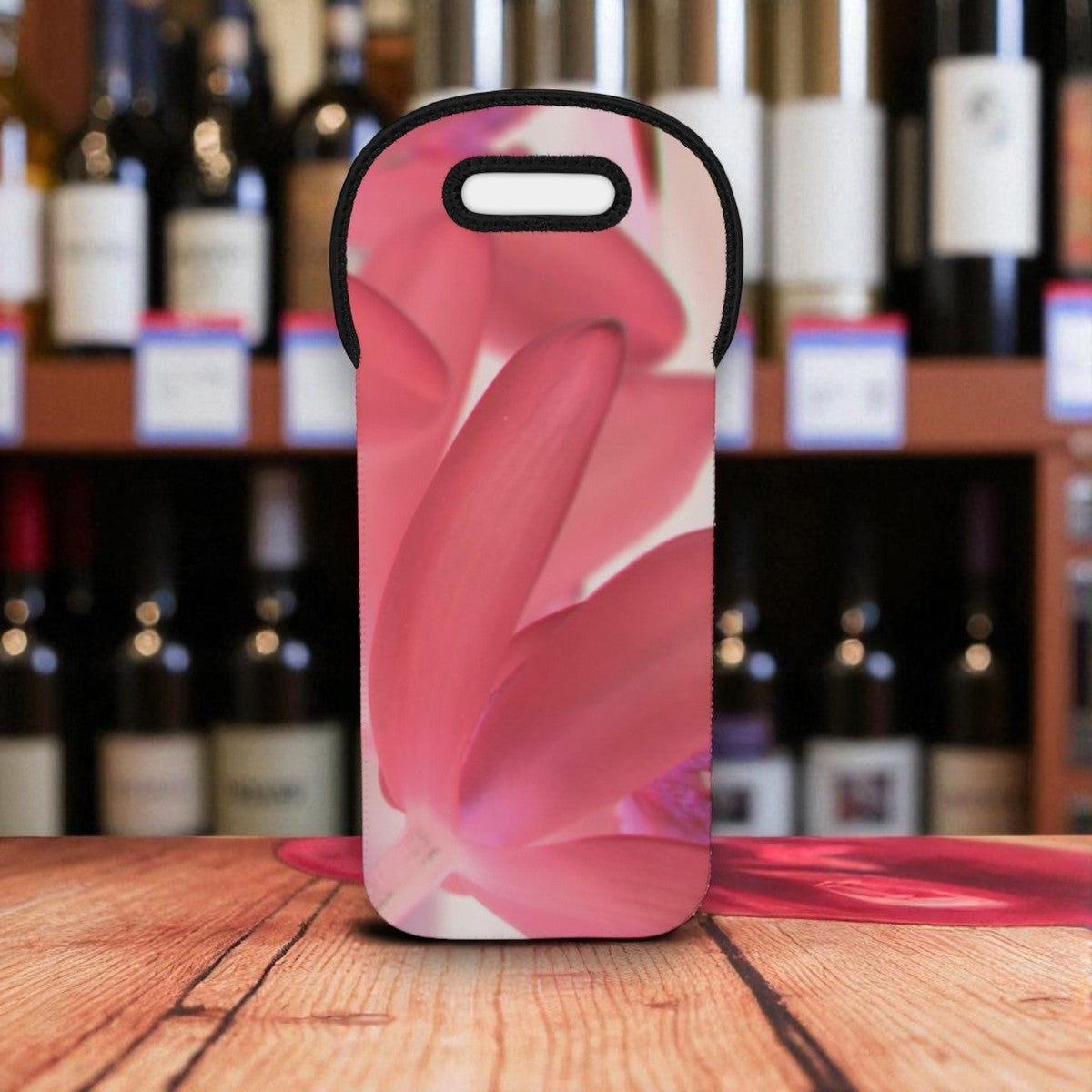 Phone case with pink floral design on a wooden surface with wine bottles in the background